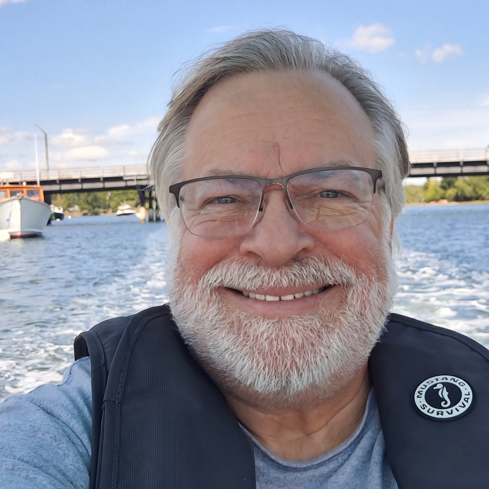 Photo of David Miller in his boat, smiling.
